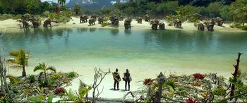 Movie still from “Monster Hunter” (2020), directed by Paul W.S. Anderson – Two people standing on the beach looking out at a herd of elephants; Extreme Wide shot, High angle