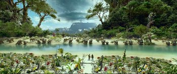 Movie still from “Monster Hunter” (2020), directed by Paul W.S. Anderson – Two people are standing in front of an elephant herd in the jungle; Extreme Wide shot, High angle