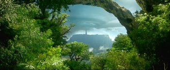 Movie still from “Monster Hunter” (2020), directed by Paul W.S. Anderson – A view of a mountain from a forest with trees in the foreground; Extreme Wide shot, Low angle