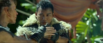 Movie still from “Monster Hunter” (2020), directed by Paul W.S. Anderson – A man in a leather jacket and a fur coat holding a gun; Close Up shot, Over the shoulder angle