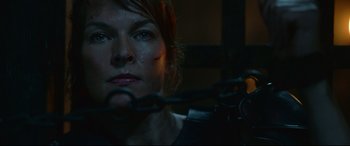 Movie still from “Monster Hunter” (2020), directed by Paul W.S. Anderson – A person with a gun in a dark room; Close Up shot, Over the shoulder angle
