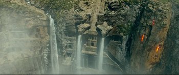 Movie still from “Monster Hunter” (2020), directed by Paul W.S. Anderson – A large waterfall with a castle on the side of it; Extreme Wide shot, Overhead angle