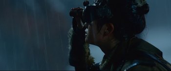 Movie still from “Monster Hunter” (2020), directed by Paul W.S. Anderson – A man looking through binoculars while wearing goggles; Close Up shot, Over the shoulder angle