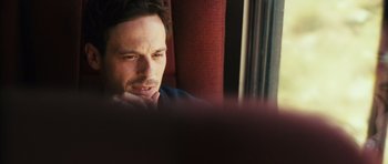 Movie still from “Monsters” (2010), directed by Gareth Edwards – A person sitting at a table; Close Up shot, Over the shoulder angle