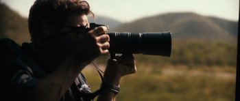 Movie still from “Monsters” (2010), directed by Gareth Edwards – A person taking a picture with a camera; Extreme Close Up shot, Low angle
