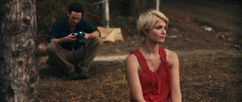 Movie still from “Monsters” (2010), directed by Gareth Edwards – A man taking a picture of a woman sitting on the ground; Medium shot, Over the shoulder angle