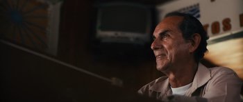 Movie still from “Monsters” (2010), directed by Gareth Edwards – An older man sitting in front of a television; Close Up shot, Low angle