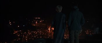 Movie still from “Monsters” (2010), directed by Gareth Edwards – Two people standing on a hill at night with candles; Wide shot, High angle