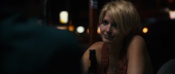Movie still from “Monsters” (2010), directed by Gareth Edwards – A woman sitting at a table with a bottle of beer; Close Up shot, Over the shoulder angle