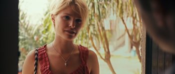 Movie still from “Monsters” (2010), directed by Gareth Edwards – A woman with short blonde hair wearing a necklace; Close Up shot, Over the shoulder angle