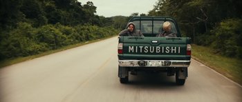 Movie still from “Monsters” (2010), directed by Gareth Edwards – Two people in the back of a green mitsubishi pickup truck; Wide shot, Over the shoulder angle