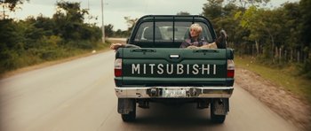 Movie still from “Monsters” (2010), directed by Gareth Edwards – A woman sitting in the back of a green mitsubishi pickup truck; Wide shot, Low angle