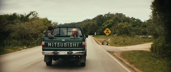 Movie still from “Monsters” (2010), directed by Gareth Edwards – Two people in the back of a green mitsubishi pickup truck; Wide shot, Over the shoulder angle