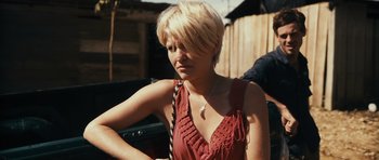 Movie still from “Monsters” (2010), directed by Gareth Edwards – A woman with blonde hair wearing a red dress; Close Up shot, Over the shoulder angle