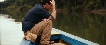 Movie still from “Monsters” (2010), directed by Gareth Edwards – A man sitting on a boat on the water; Medium shot, High angle