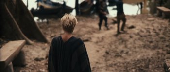 Movie still from “Monsters” (2010), directed by Gareth Edwards – A woman standing on a beach near a body of water; Wide shot, Over the shoulder angle