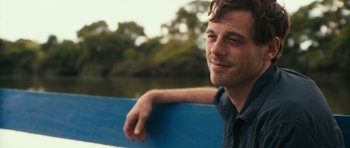 Movie still from “Monsters” (2010), directed by Gareth Edwards – A man leaning on a blue railing near a body of water; Close Up shot, Over the shoulder angle