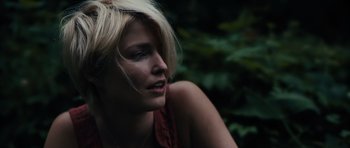 Movie still from “Monsters” (2010), directed by Gareth Edwards – A woman with blonde hair sitting in the woods; Close Up shot, Low angle