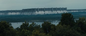 Movie still from “Monsters” (2010), directed by Gareth Edwards – A view of a dam with trees in the foreground; Extreme Wide shot, Low angle