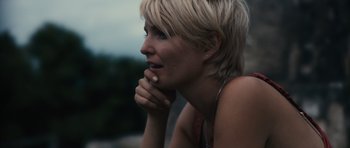 Movie still from “Monsters” (2010), directed by Gareth Edwards – A woman with blonde hair is looking to her left; Close Up shot, Over the shoulder angle