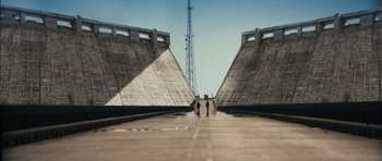 Movie still from “Monsters” (2010), directed by Gareth Edwards – Two skateboarders are walking down a concrete path; Extreme Wide shot, Low angle