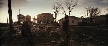 Movie still from “Monsters” (2010), directed by Gareth Edwards – A man standing in the middle of a pile of debris; Wide shot, Over the shoulder angle