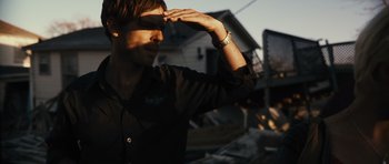 Movie still from “Monsters” (2010), directed by Gareth Edwards – A man saluting while standing in front of a building; Close Up shot, Low angle