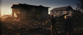 Movie still from “Monsters” (2010), directed by Gareth Edwards – A man standing in front of a house that is destroyed; Extreme Wide shot, Low angle