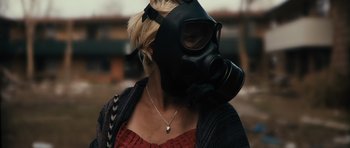 Movie still from “Monsters” (2010), directed by Gareth Edwards – A woman wearing a gas mask and a necklace; Close Up shot, Over the shoulder angle
