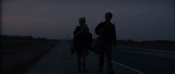 Movie still from “Monsters” (2010), directed by Gareth Edwards – A man and a woman walking down a street at night; Wide shot, Low angle