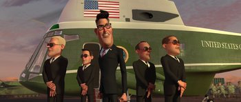 Movie still from “Monsters vs. Aliens” (2009), directed by Conrad Vernon – A group of men standing next to each other in front of an airplane; Medium shot, Low angle