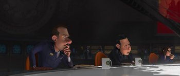 Movie still from “Monsters vs. Aliens” (2009), directed by Conrad Vernon – Two cartoon characters sitting at a table with a cup; Medium shot, Over the shoulder angle