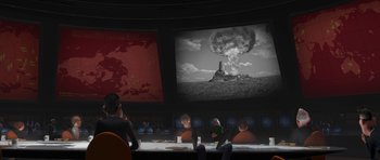 Movie still from “Monsters vs. Aliens” (2009), directed by Conrad Vernon – A group of people sitting at a table in front of a large screen; Extreme Wide shot, Over the shoulder angle