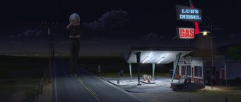 Movie still from “Monsters vs. Aliens” (2009), directed by Conrad Vernon – A woman standing on the side of a road next to a table; Wide shot, Low angle