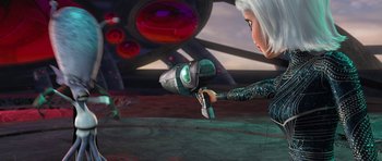 Movie still from “Monsters vs. Aliens” (2009), directed by Conrad Vernon – An image of a woman holding a gun in the air; Medium shot, Over the shoulder angle