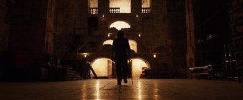 Movie still from “Moon Knight” (2022), directed by Mohamed Diab – A person with a cane walking in a dark room; Extreme Wide shot, Low angle