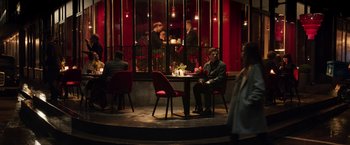 Movie still from “Moon Knight” (2022), directed by Mohamed Diab – A group of people sitting at a table outside a restaurant; Wide shot, High angle