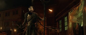 Movie still from “Moon Knight” (2022), directed by Mohamed Diab – A statue of a man holding a staff in the dark; Wide shot, Low angle