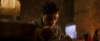 Movie still from “Moon Knight” (2022), directed by Mohamed Diab – A man sitting at a table with a plate in his hand; Close Up shot, Low angle