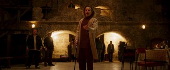 Movie still from “Moon Knight” (2022), directed by Mohamed Diab – A man with a cane standing in front of a group of people; Wide shot, Low angle