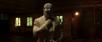 Movie still from “Moon Knight” (2022), directed by Mohamed Diab – A man wearing a suit and tie with a mask on; Medium shot, Low angle