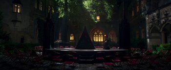 Movie still from “Moon Knight” (2022), directed by Mohamed Diab – An outdoor stage with a man sitting on the stage; Extreme Wide shot, High angle