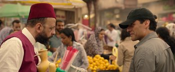 Movie still from “Moon Knight” (2022), directed by Mohamed Diab – A crowd of people at an open air market; Medium shot, Over the shoulder angle