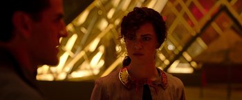 Movie still from “Moon Knight” (2022), directed by Mohamed Diab – A woman in a brown jacket and a yellow necklace; Close Up shot, Low angle