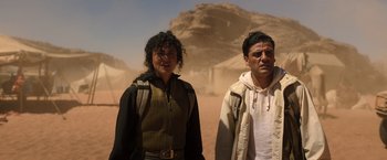 Movie still from “Moon Knight” (2022), directed by Mohamed Diab – A man and a woman standing next to each other in the desert; Medium shot, Over the shoulder angle