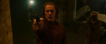 Movie still from “Moon Knight” (2022), directed by Mohamed Diab – A man holding a gun while standing in a dark room; Close Up shot, Over the shoulder angle