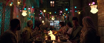 Movie still from “Moon Knight” (2022), directed by Mohamed Diab – A group of people sitting around a table eating food; Wide shot, High angle