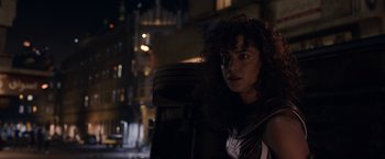 Movie still from “Moon Knight” (2022), directed by Mohamed Diab – A woman standing in the dark near a building; Close Up shot, Over the shoulder angle