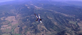 Movie still from “Moonraker” (1979), directed by Lewis Gilbert – A man is in the air with a parachute; Extreme Wide shot, High angle