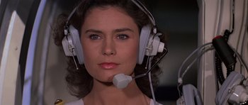 Movie still from “Moonraker” (1979), directed by Lewis Gilbert – A woman wearing headphones and a microphone; Close Up shot, Low angle